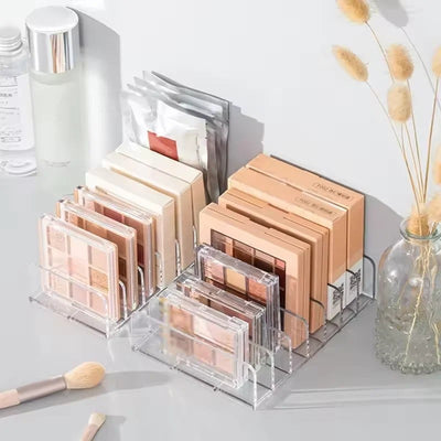 Nice Top Teck clear acrylic 7-compartment makeup organizer holding eyeshadow palettes on a vanity table